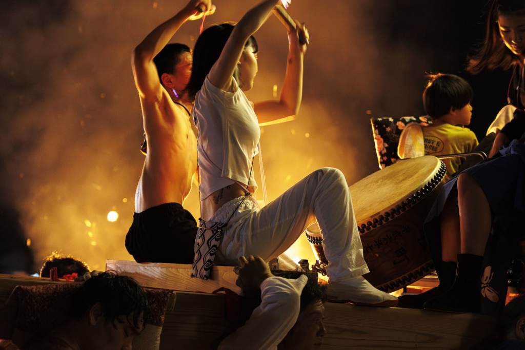 A boy and girl play the taiko drums