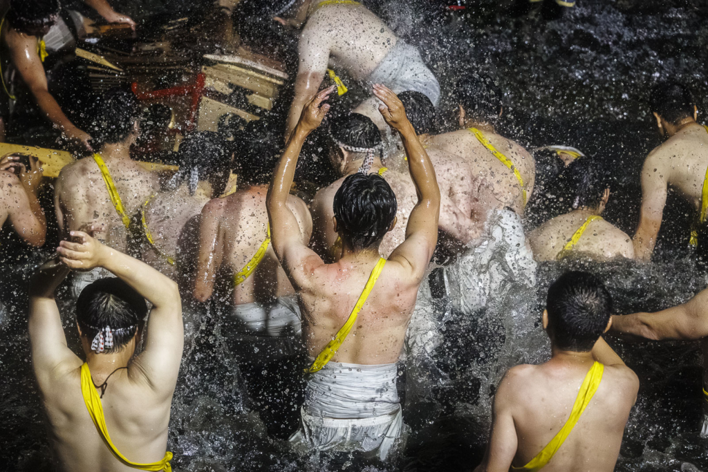 Men in the river throw water ate the Mikoshi