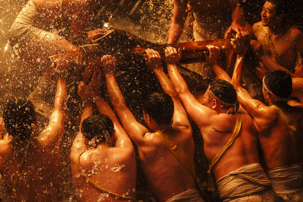 Men in the river crash the mikoshi with embers falling from above