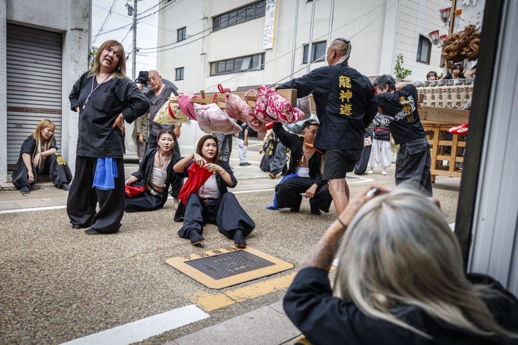 People resting from carrying Kiriko lantern floats